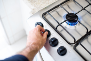 Stock image of someone turning on a stove.